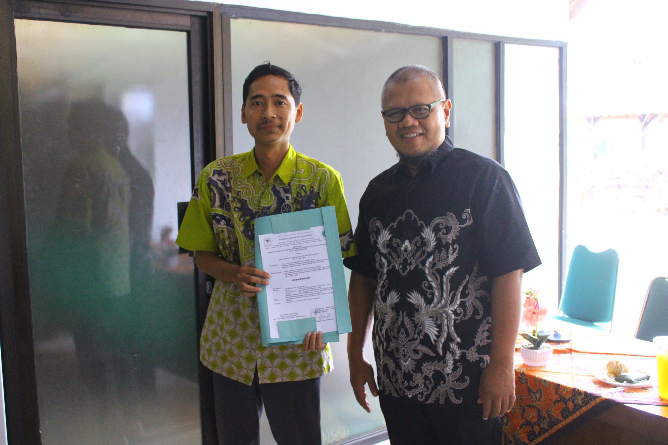 "Estafet Kepemimpinan untuk Pendidikan yang Lebih Unggul — Ketua Yayasan Masmahdani melantik Herlambang Gilang S.N., S.Kom., M.M. sebagai Kepala Sekolah SMK Wihdatul Ummah, disaksikan Pembina Yayasan, Pimpinan Pondok Pesantren, serta seluruh guru dan staf."